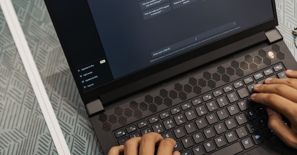 Handen op een laptoptoetsenbord met een donker scherm vol technische tekst, zoals een robots.txt-bestand